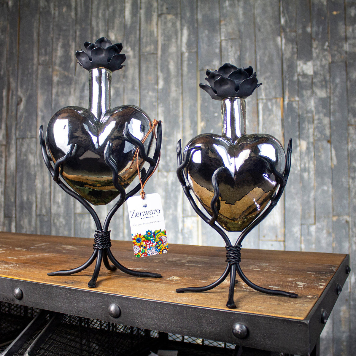 Two heart shaped glass urns with metal stands.