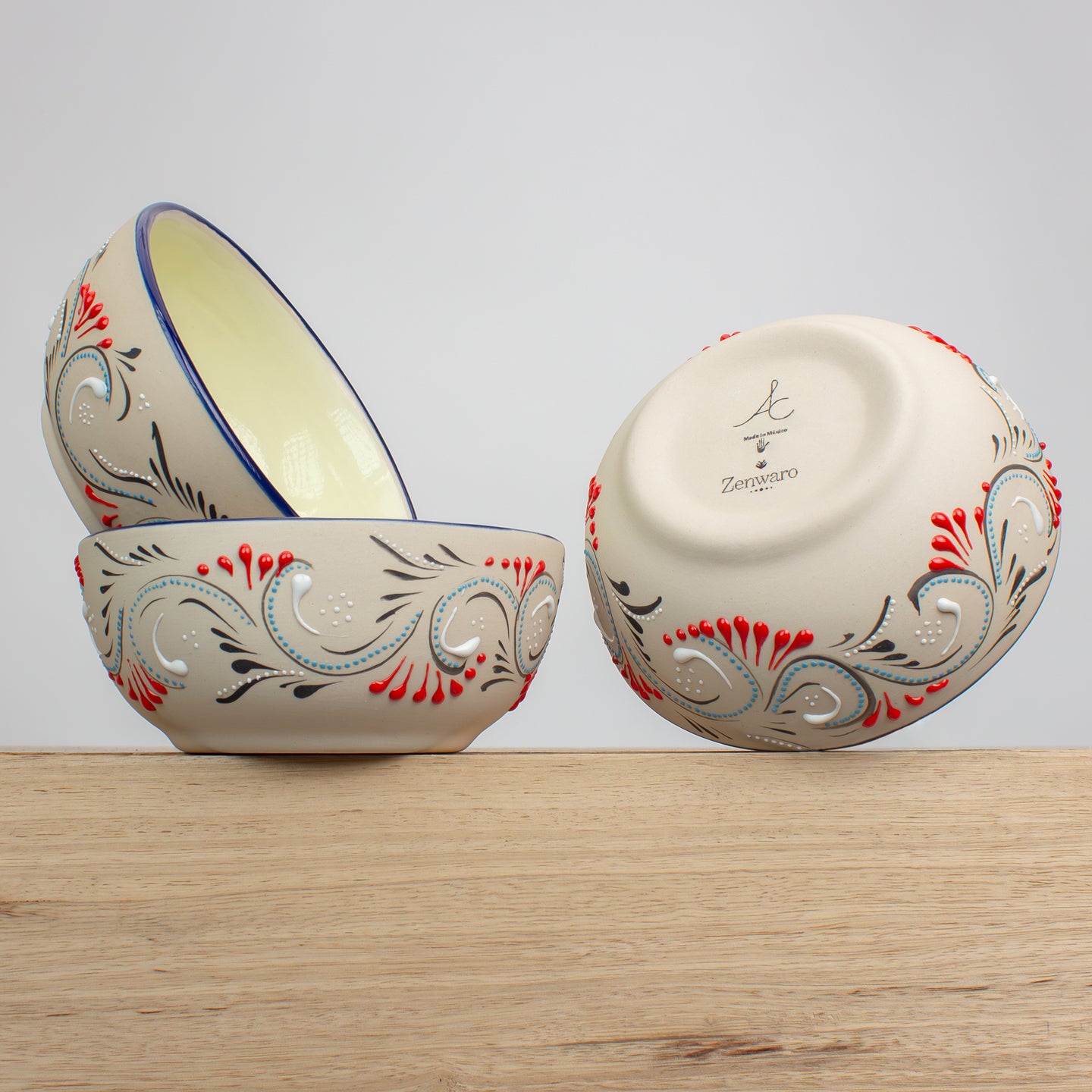 Stoneware bowls with hand painted decorative patterns on a wooden counter
