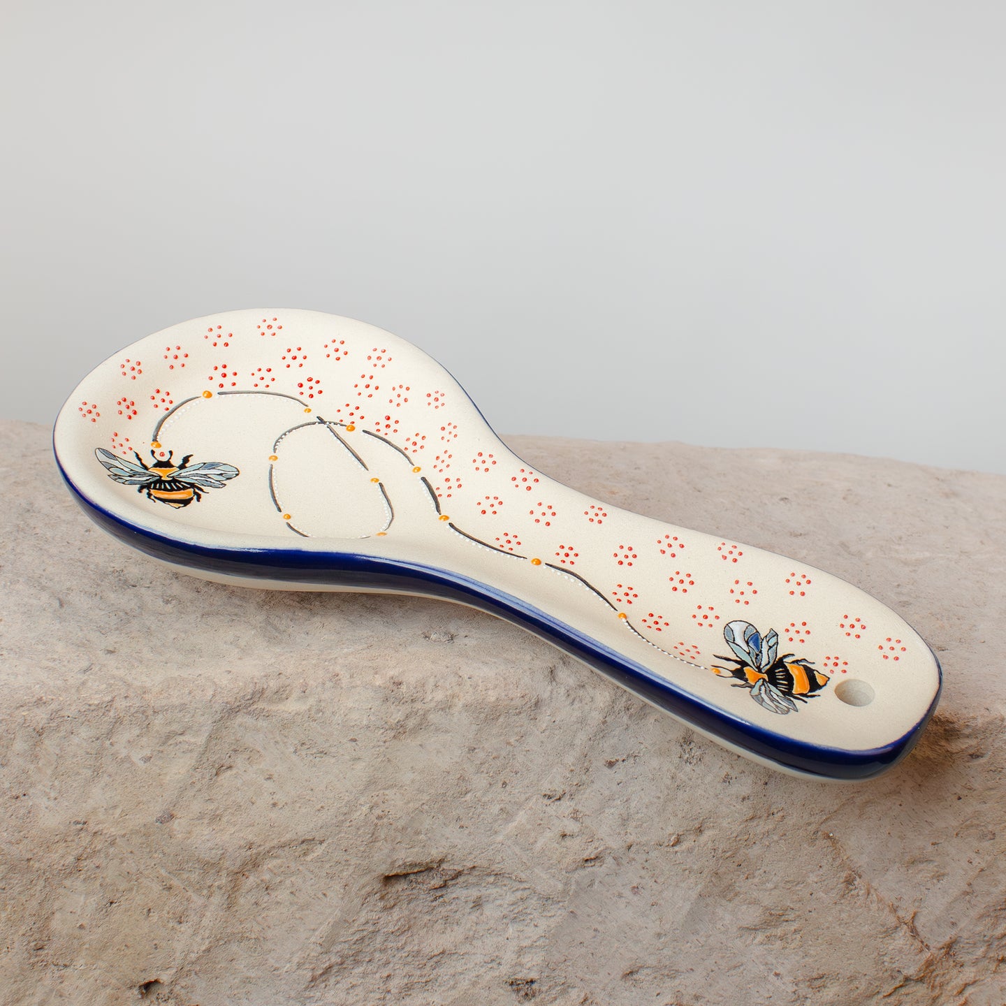 Decorative spatula rest with bee design on stone kitchen counter