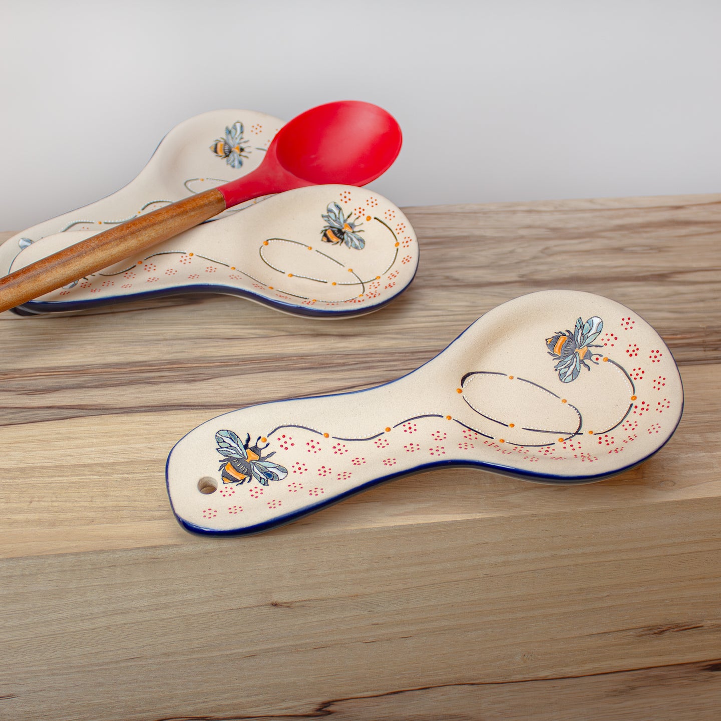 Decorative ceramic spoon rest on wood dining tabletop.
