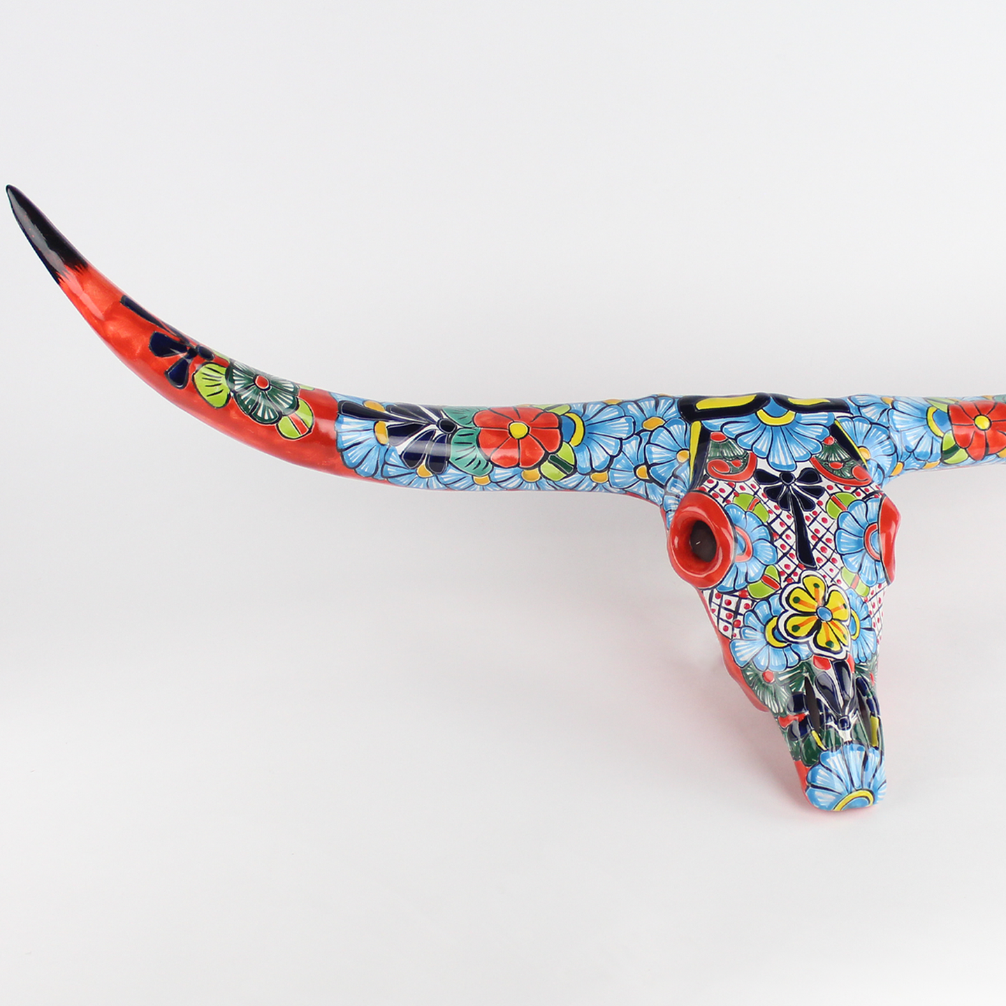 Decorative cow skull with colorful floral pattern.