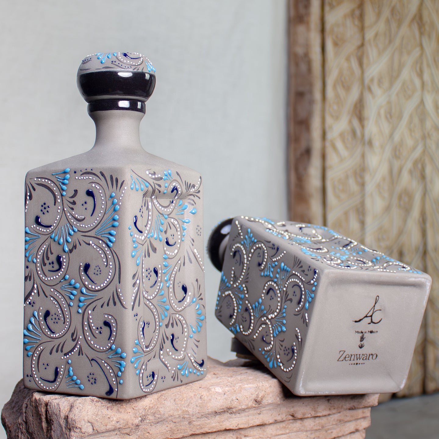 Ceramic decanters with intricate blue patterns on stone surface.
