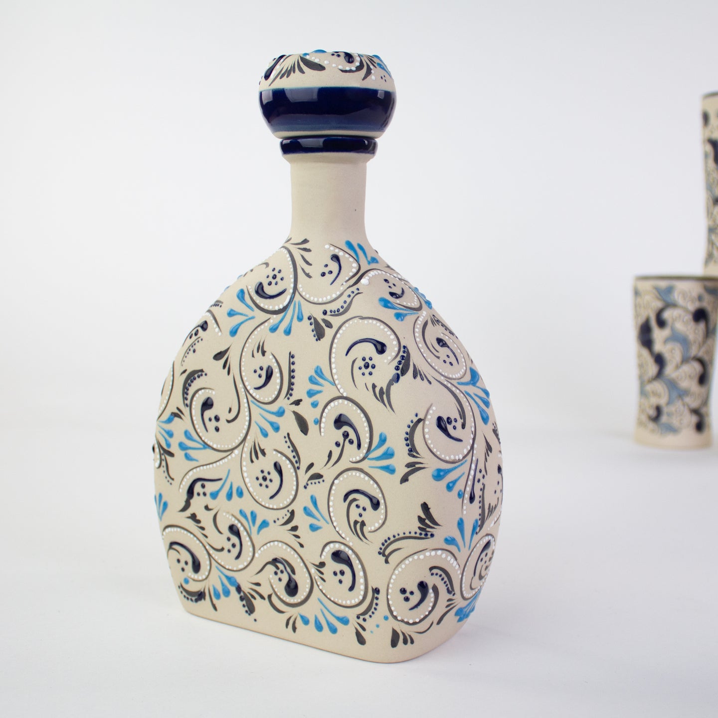Ceramic bottle with decorative blue white  and black hand painted patterns.