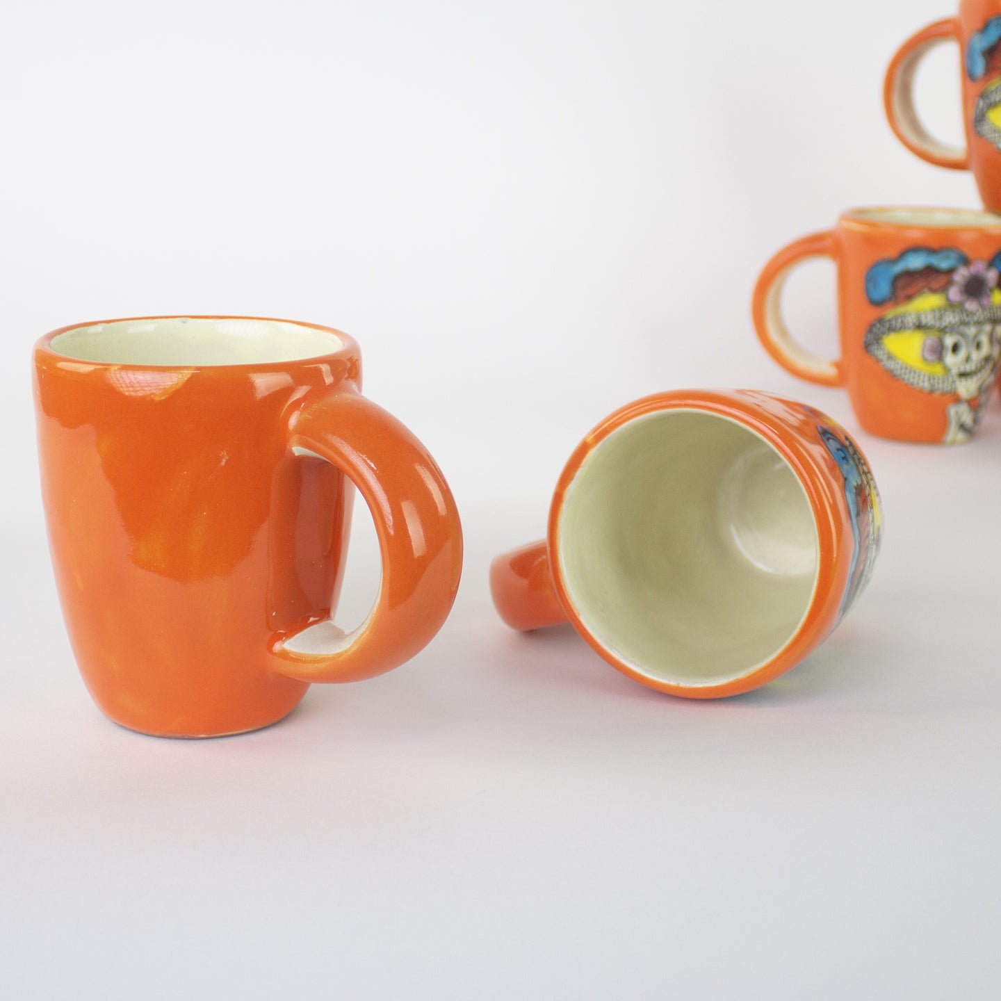 Orange ceramic mug with a handle Ceramic mugs with hand painted day of the dead artwork.