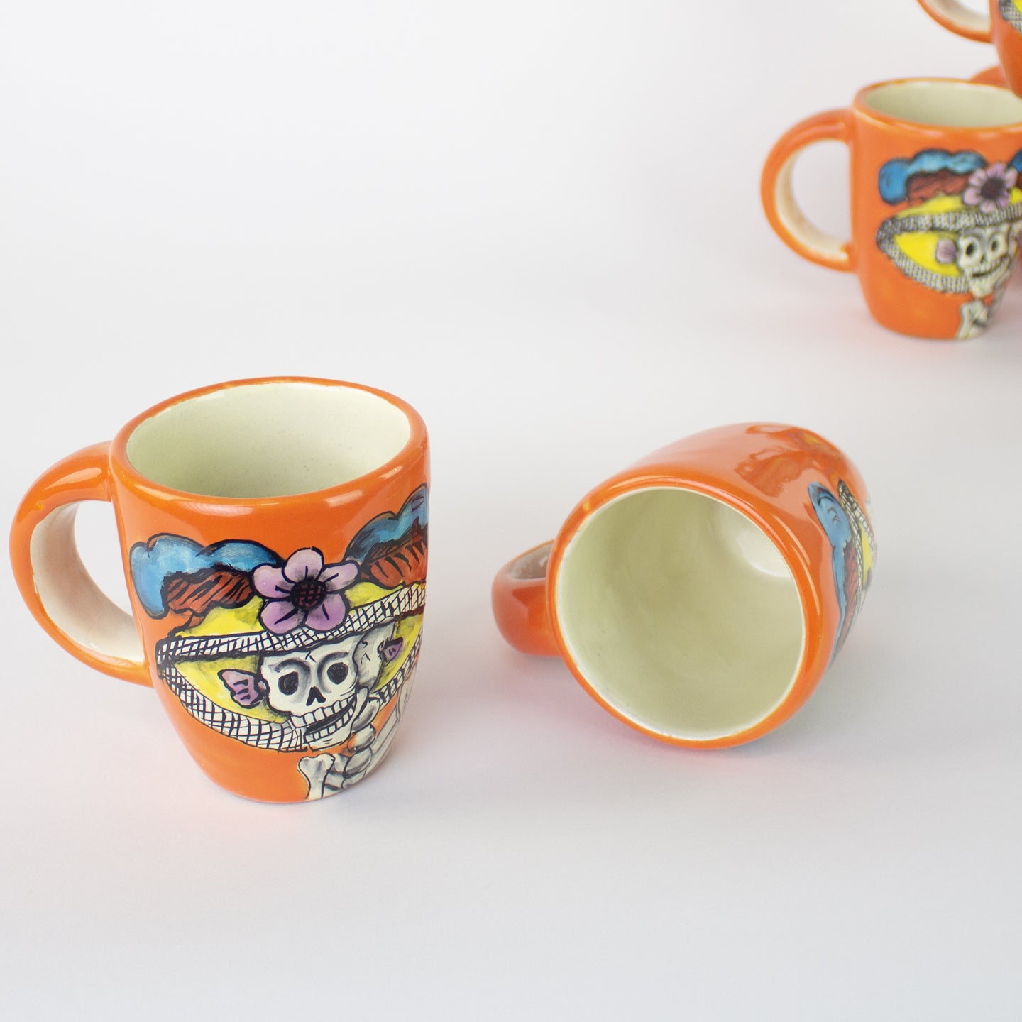 Ceramic mugs with hand painted day of the dead artwork.