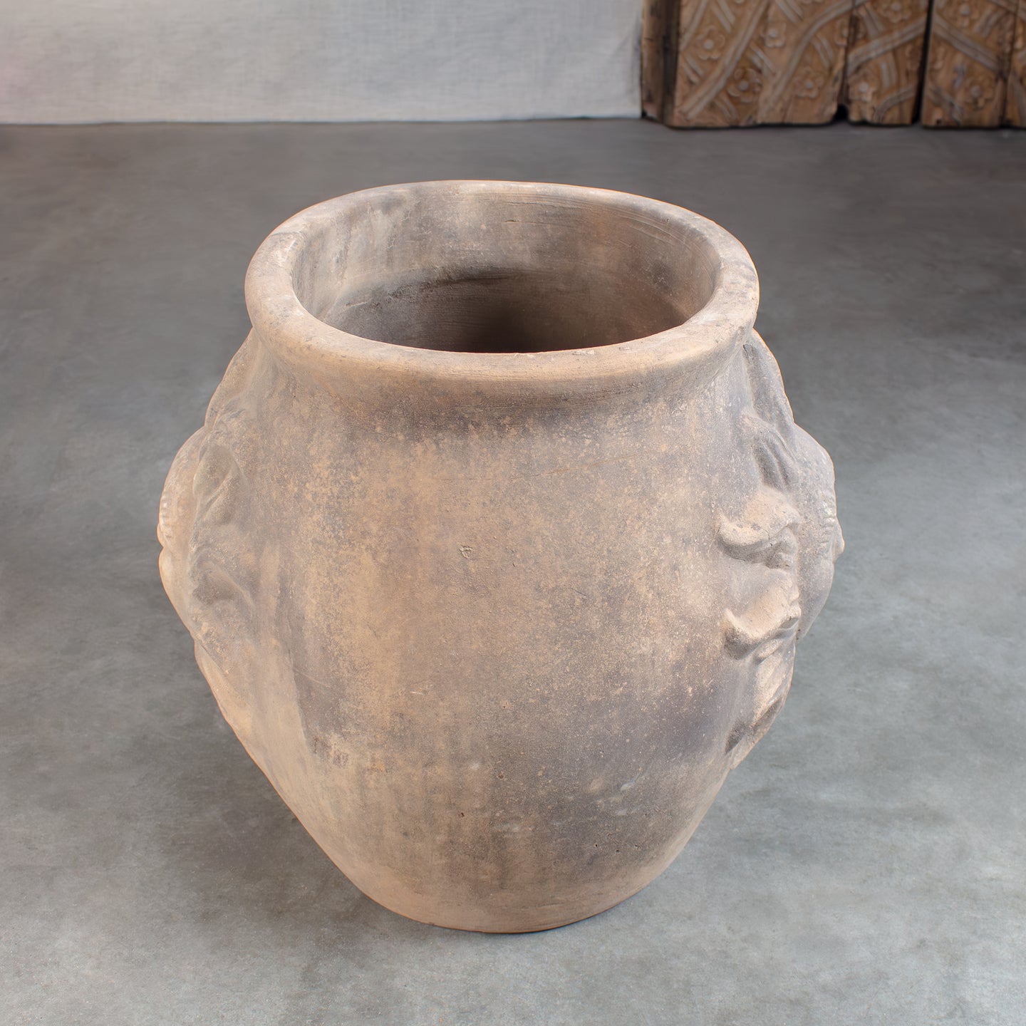Vintage terracotta pot oval shape with large sun faces on either side.