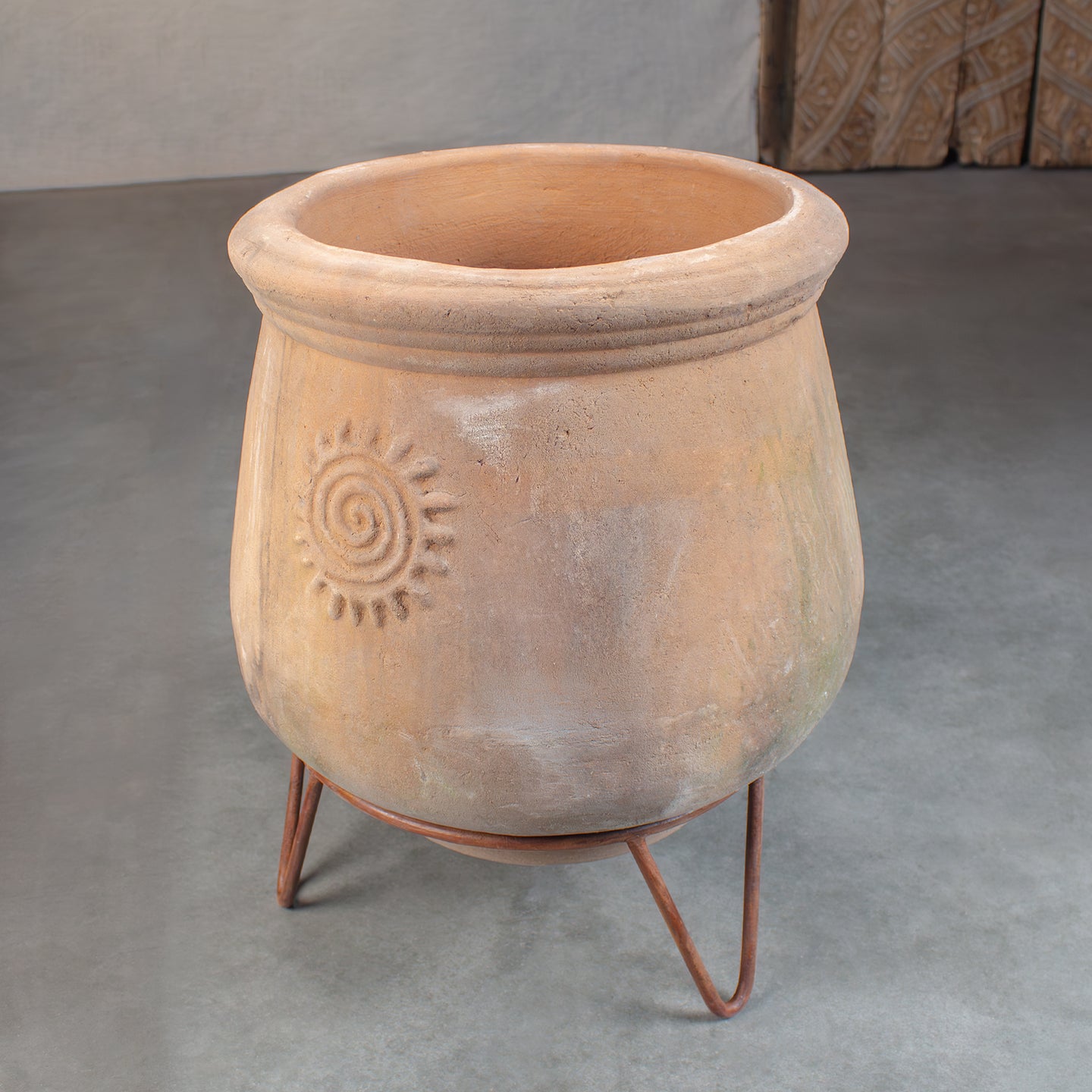 Vintage Terracotta pot with sun sitting on metal pot stand with three legs