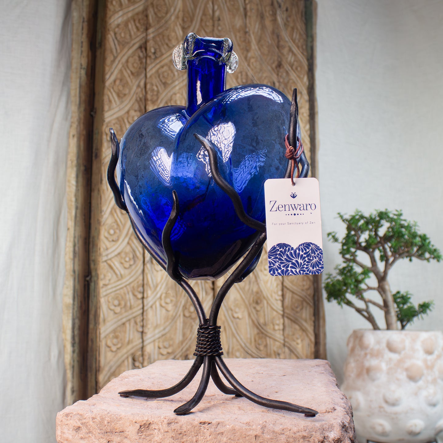Large size cobalt blue glass heart vase with a sculpted iron vine stand.