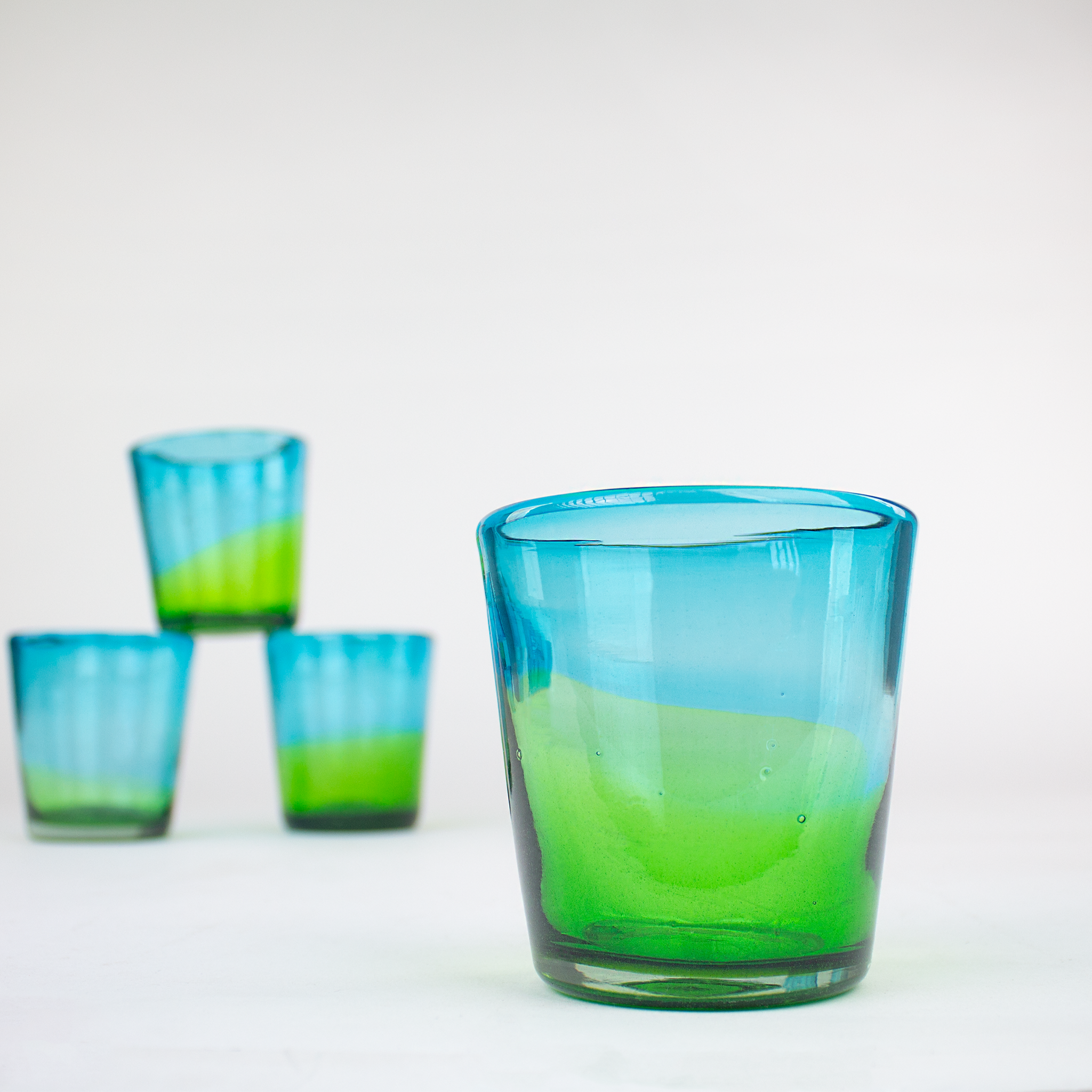 Hand-blown glass tumblers, aqua and lime glass cups.