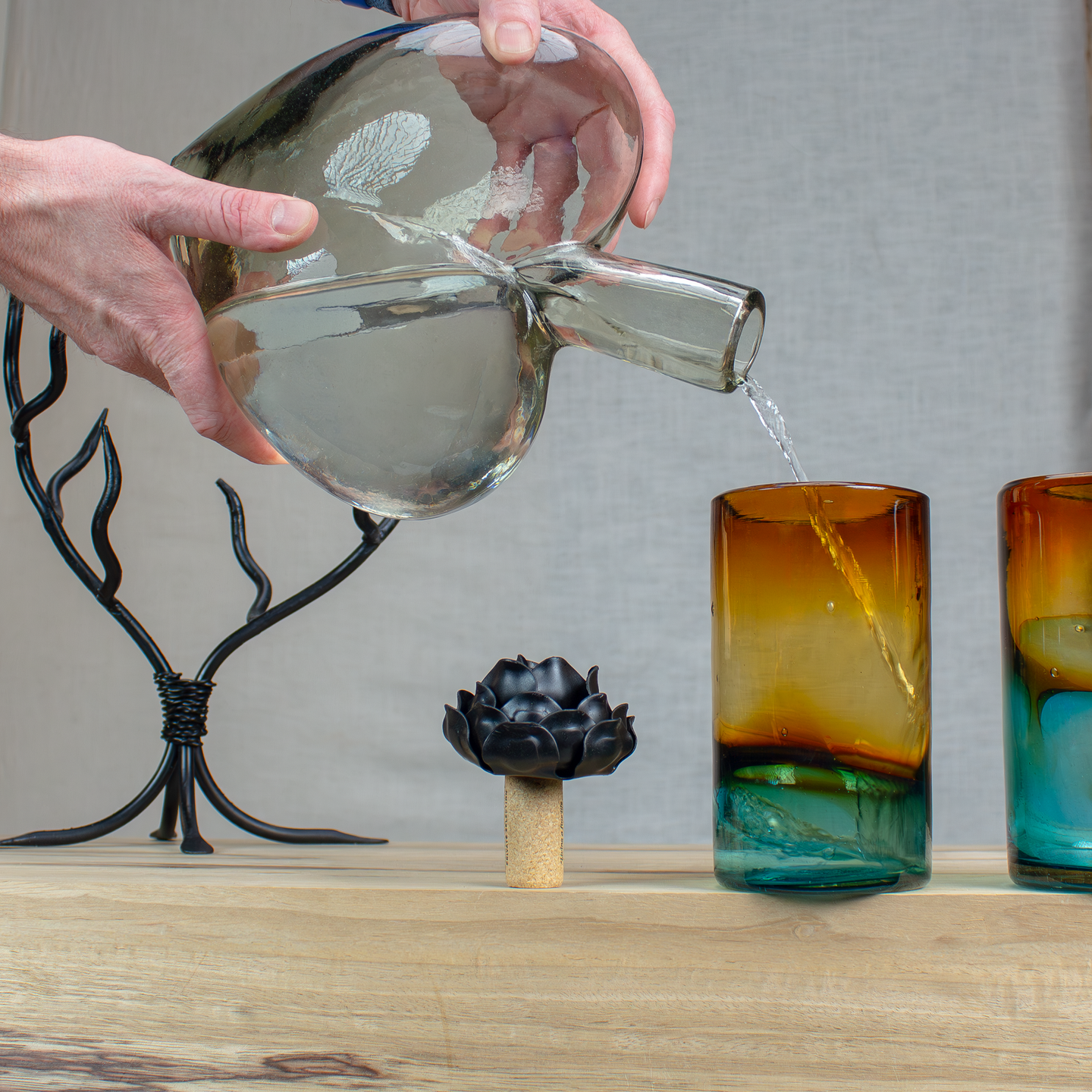 Glass heart decanter pouring into a glass cup.