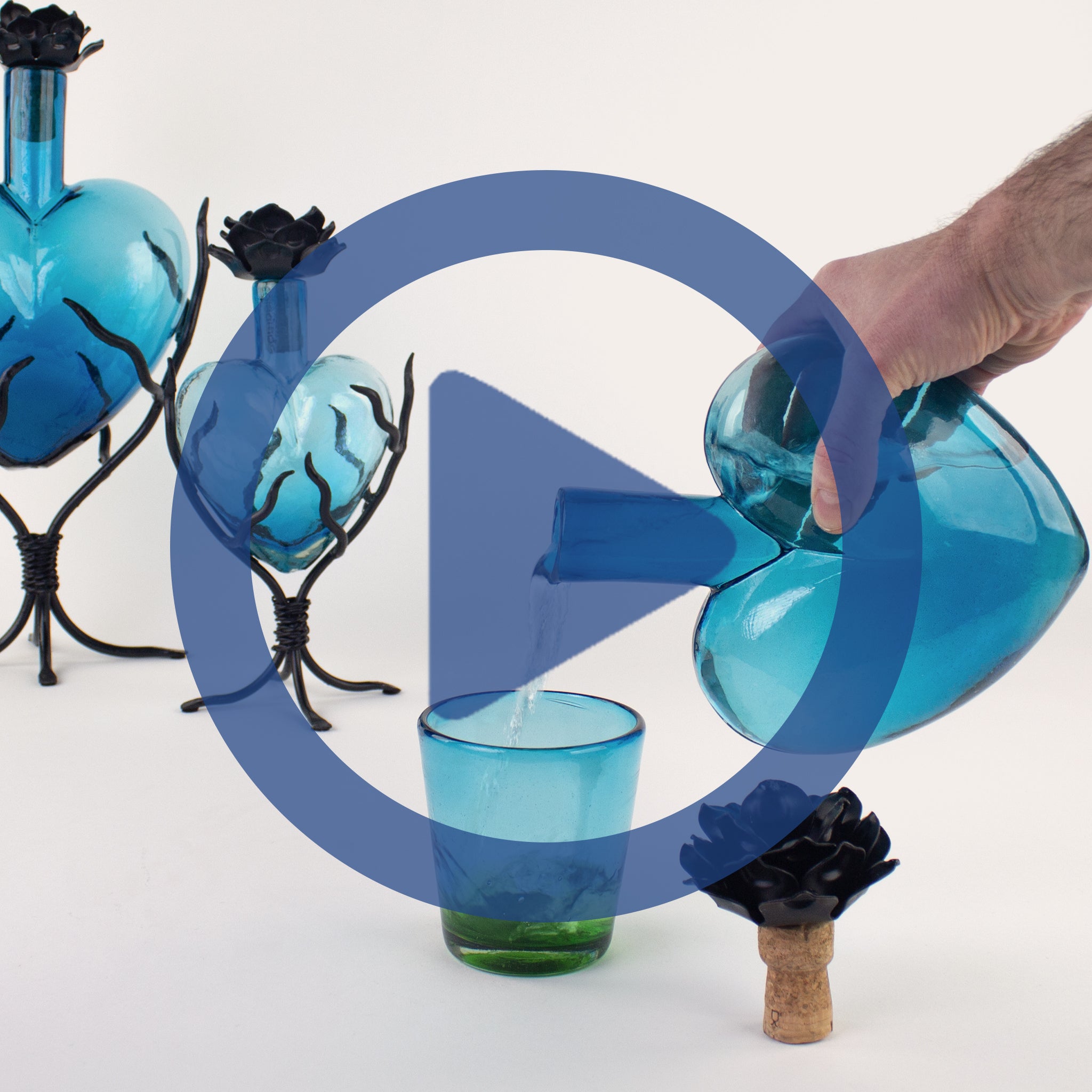 Sculptural Glass decanter being pouring into a colorful glass cup.